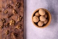 Walnuts in wooden bowl and on wooden carved board on bright textured surface. Healthy nuts and seeds composition. Royalty Free Stock Photo