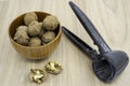 Walnuts in a bowl with a nutcracker next to it on the table Royalty Free Stock Photo