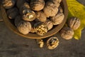 Walnuts in a wooden plate on rustic table