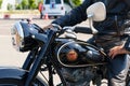 A black Simson AWO Sport motorcycle parked in front of a Burgenland classic.