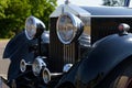 A vintage Rolls Royce Phantom. Front view of the bumper, hood, grille and headlights.