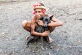 Wamena, Indonesia - January 9, 2010: Man of the Dani tribe sitting with dog, Dugum Dani Village, Indonesian New Guinea