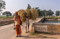 Wandering Sadhu amd man with straw on his back, Bullapur, Karnataka, India