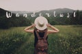 Wanderlust text sign concept, hipster traveler woman holding hat Royalty Free Stock Photo