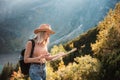 Wanderlust and travel concept. Stylish traveler girl in hat looking at map, exploring woods