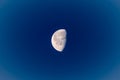 Waning moon in broad daylight with blue sky, in the morning at the beginning of the year