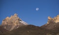 The waning moon in the mountains against the background of a blue sky with rocks and mountains Royalty Free Stock Photo