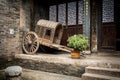 Empty ancient Chinese cart resting against a brick wall