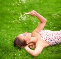 Want to come chill at the park with me. a young woman using her cellphone while lying on the grass. Royalty Free Stock Photo