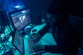 Wanted hackers coding virus ransomware using laptops and computers. Cyber attack, system breaking and malware concept.