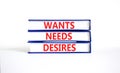 Wants needs and desires symbol. Concept words Wants Needs Desires on books. Beautiful white table white background. Business,