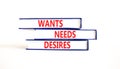 Wants needs and desires symbol. Concept words Wants Needs Desires on books. Beautiful white table white background. Business,