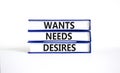 Wants needs and desires symbol. Concept words Wants Needs Desires on books. Beautiful white table white background. Business,