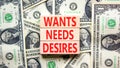 Wants needs and desires symbol. Concept words Wants Needs Desires on wooden blocks. Beautiful background from dollar bills.