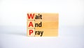 WAP, Wait and pray symbol. Wooden blocks with concept words `WAP, Wait and pray`. Beautiful white background, copy space. Religi