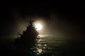 Silhouettes of a crowd standing at blurred military war ship on foggy background. Selective focus