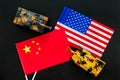 War, confrontation concept. China, USA. Tanks toy near chinese and american flag on black background top view Royalty Free Stock Photo