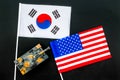 War, confrontation concept. Korea, USA. Tanks toy near korean and american flag on black background top view Royalty Free Stock Photo