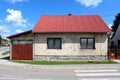 War damaged small suburban family house with still visible shrapnel holes in rusted metal garage doors and dilapidated facade