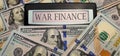 War finance. A calculator surrounded by 100 US dollar bills. Concept of militarization