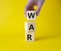 War symbol. Wooden cubes with word War. Businessman hand. Beautiful yellow background. Business and War concept. Copy space Royalty Free Stock Photo