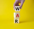 War symbol. Wooden cubes with word War. Businessman hand. Beautiful yellow background. Business and War concept. Copy space Royalty Free Stock Photo