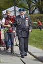 War veteran - serior man and yound man walking in a a park.