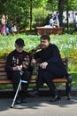 A war veteran sits on a bench by a young man.