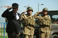 A War Veteran and Soldiers Saluting in Front of Military Truck