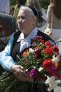 War veteran woman portrait. She holds flowers.