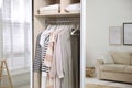 Wardrobe closet with different stylish clothes in room, closeup Royalty Free Stock Photo