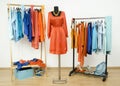 Wardrobe with complementary colors orange and blue clothes arranged on hangers.