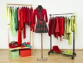 Wardrobe with complementary colors red and green clothes arranged on hangers.