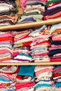 A wardrobe full of childrens clothes creative background texture. Lots of rows of colorful kids clothing laying neatly aligned