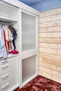 Wardrobe with matte glass on sliding door near wooden wall