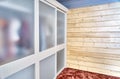 Wardrobe with matte glass on sliding door near wooden wall