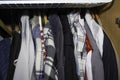 Wardrobe overflowing and colorfully mixed with jackets and pants, sweaters Royalty Free Stock Photo