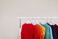 Wardrobe rack with different bright clothes on light background. Royalty Free Stock Photo