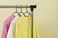 Wardrobe rack with sweatshirts against beige background