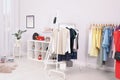 Wardrobe racks with different stylish clothes in room