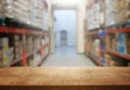 warehouse background, wooden empty table and blurred storage shelfs. Ready for mock up or product display industry Royalty Free Stock Photo