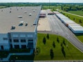 Warehouse on a busy street corner, with multiple delivery trucks parked around it on a sunny day