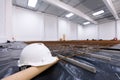 Warehouse construction site. White engineer helmet on floor