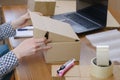 Warehouse employee packs the order of the online store in a cardboard box