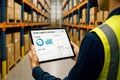 Warehouse employee with tablet showing smart logistics warehouse data and productivity charta Royalty Free Stock Photo