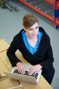 Warehouse employee typing on laptop computer