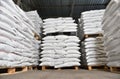 Warehouse filled with white heavy bags that lie on pallets