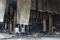 After a warehouse fire, black charred steel plates hang from the ceiling like rags. Non-observance of fire safety