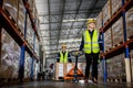 Warehouse industrial stock storage, Team warehouse worker wear safety uniform push load cart product to shelf in warehouse store. Royalty Free Stock Photo