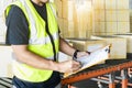 Warehouse inventory management, Warehouse worker holding clipboard checking shipment boxes in warehouse storage. Royalty Free Stock Photo